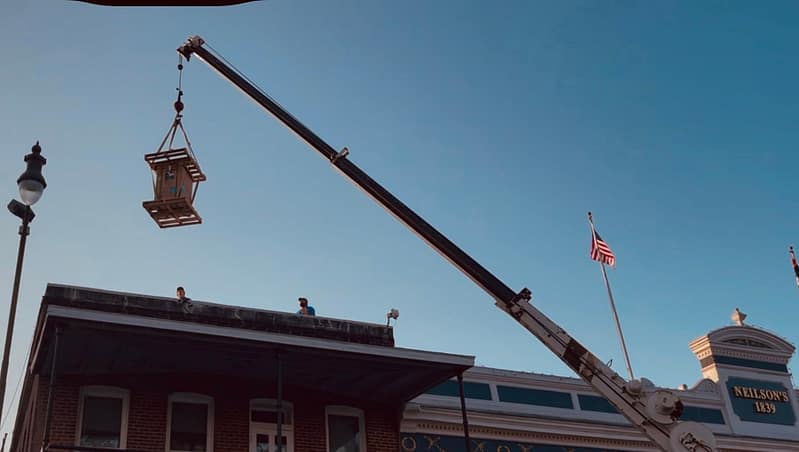 using crane to lift new replacement ac onto commercial building roof in Oxford, MS 