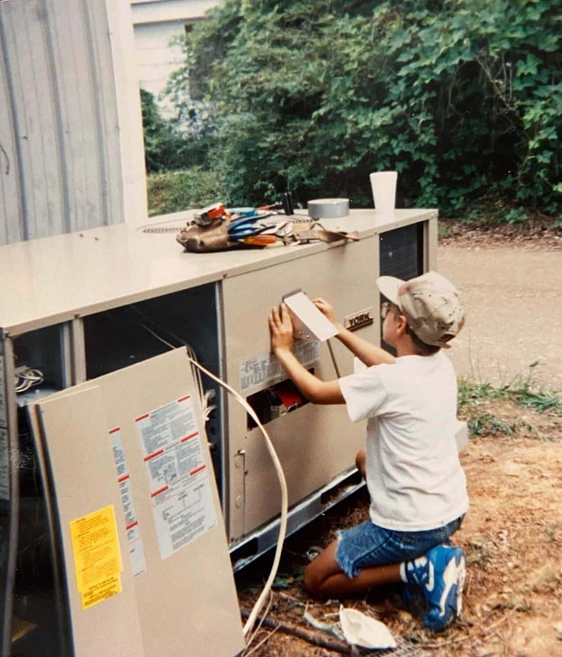 Jay Lovett working on an HVAC unit as a boy